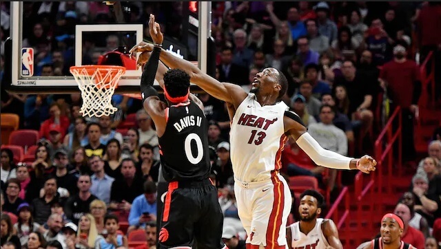 Bam Adebayo dari Miami Heat melakukan Dunk dan coba diblok oleh Davis Terence dari Toronto Raptors